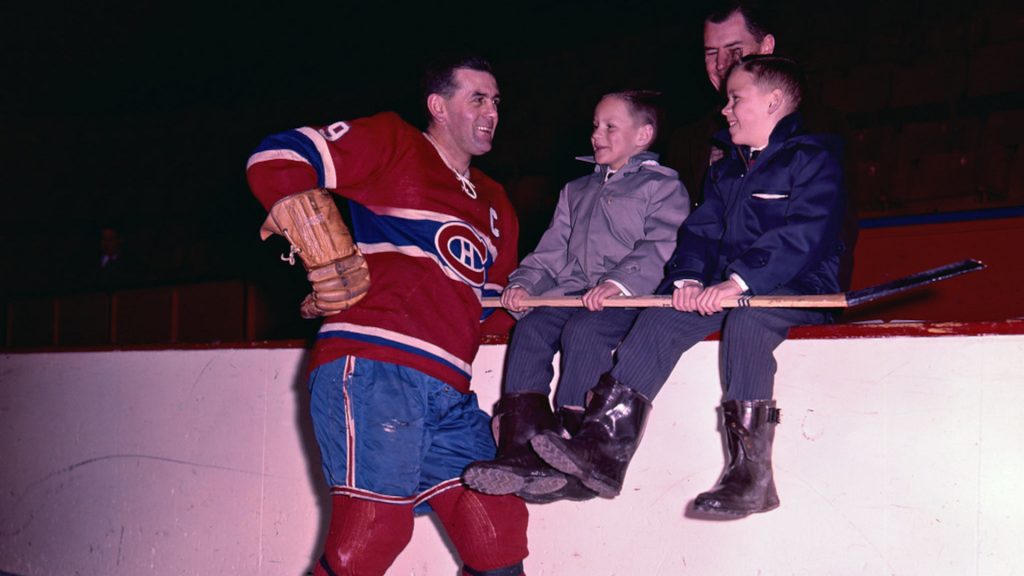 Maurice Richard posando para uma foto com duas crianças.