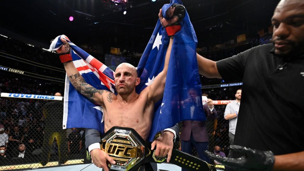 Alexander Volkanovski celebrating with his featherweight title. 