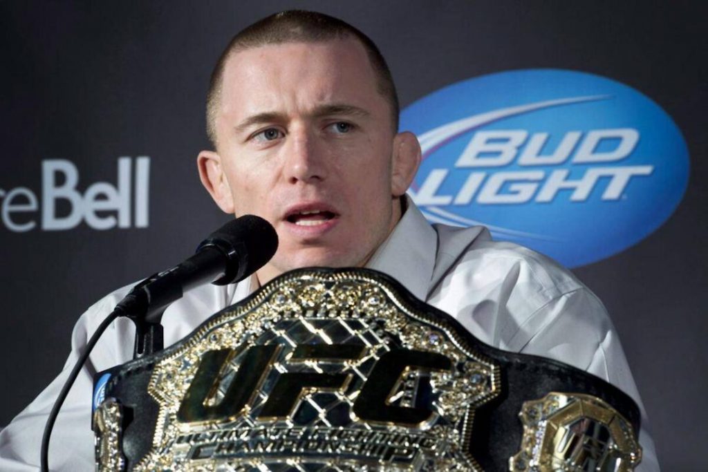 Georges St-Pierre com seu cinturão do UFC em uma coletiva de imprensa.