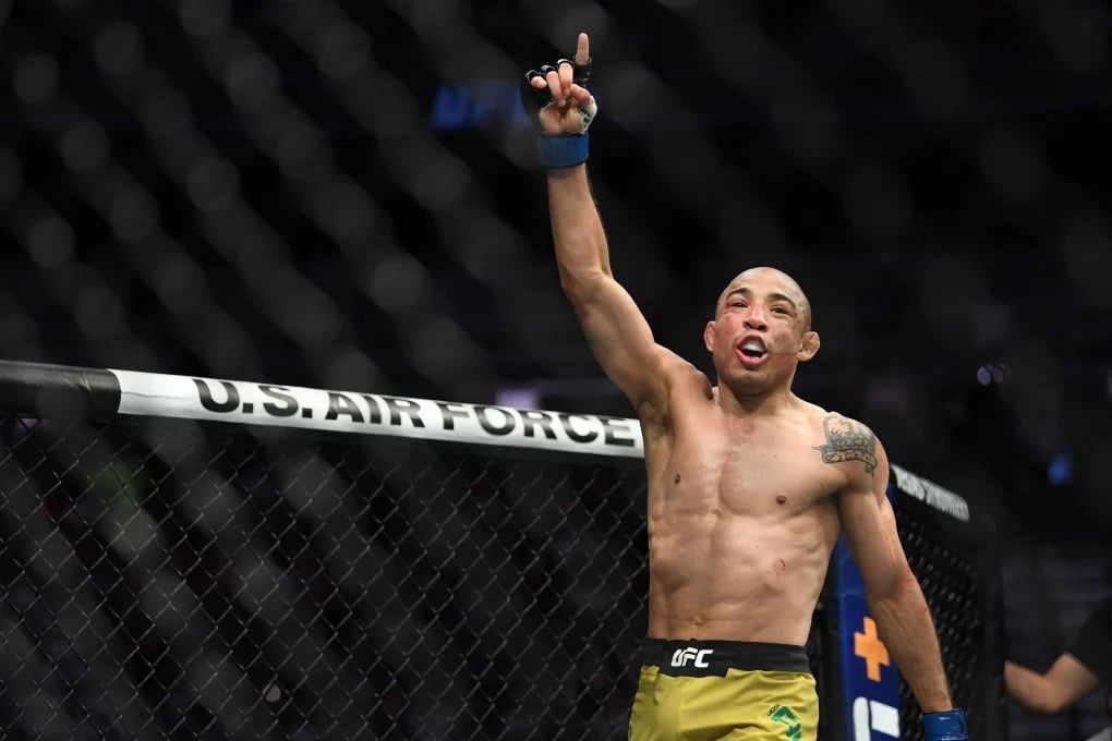 Jose Aldo celebrating a win in the octagon.