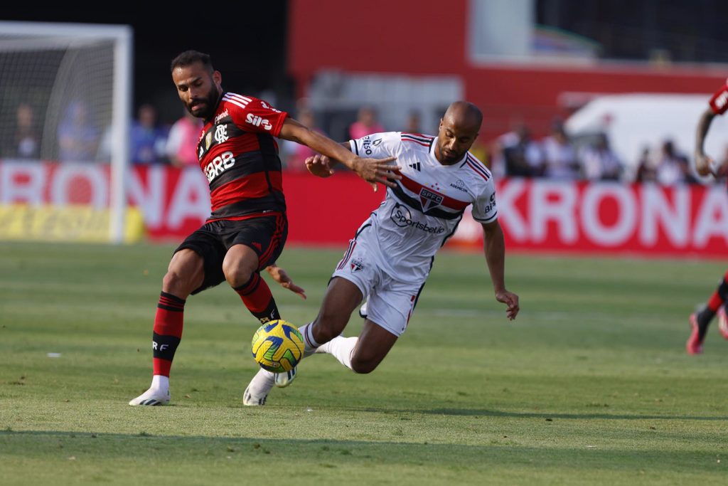 Lucas Moura, do São Paulo, divide bola com jogador do Flamengo.