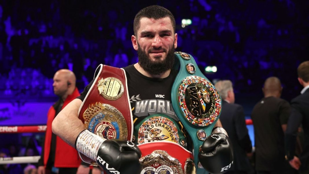 A photo of Russian boxer Artur Beterbiev holding two belts after a fight