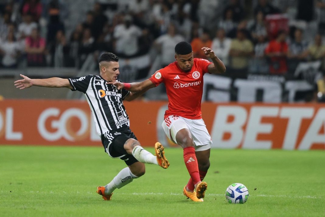 Jogadores de Atlético-MG e Internacional disputam a bola em jogo do Brasileirão.