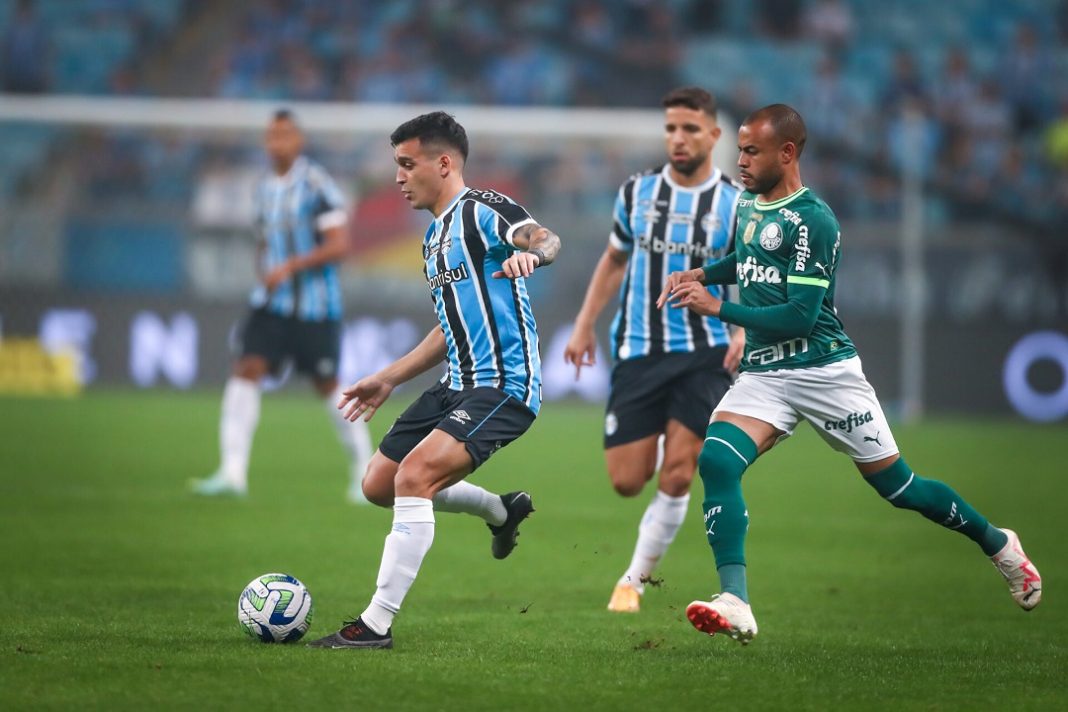 Disputa de bola entre jogadores do Palmeiras e do Grêmio durante jogo do Brasileirão 2024.