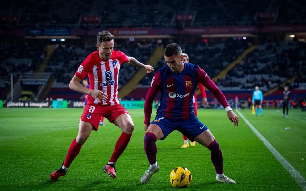 Jogadores do Barcelona e do Atlético de Madrid em disputa de bola, durante jogo de La Liga, o Campeonato Espanhol.