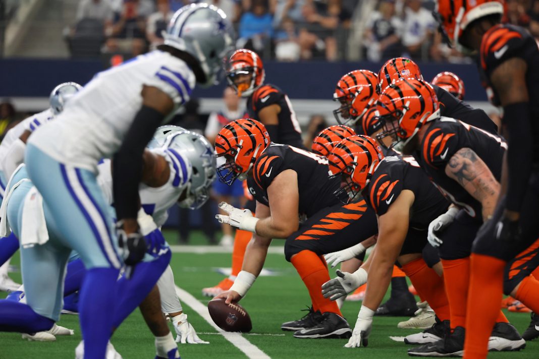 Jogadores de Dallas Cowboys e Cincinnati Bengals alinhados na linha de scrimmage em jogo da NFL.