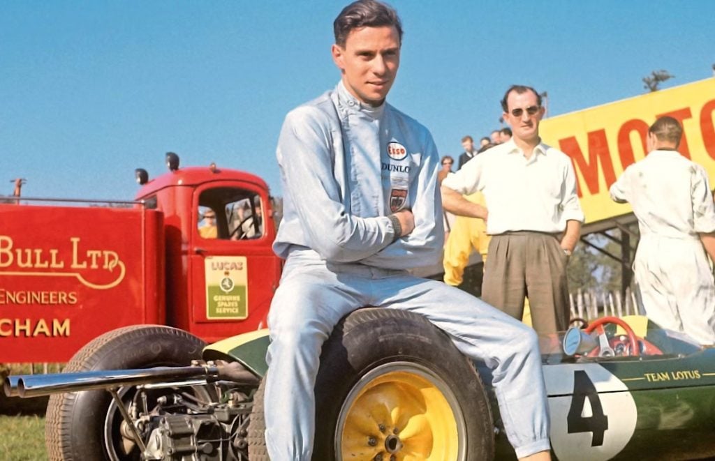 Jim Clark sat on the wheel of his Lotus F1 car