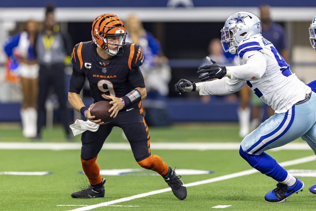 Joe Burrow, quarterback do Cincinnati Bengals, é perseguido por defensor do Dallas Cowboys em partida da NFL.