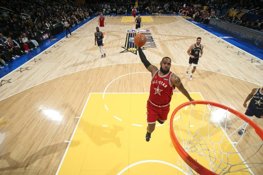 Lebron James enterrando bola em partida da NBA.