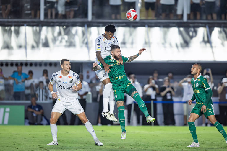 Disputa de bola no alto entre jogadores do Santos e Palmeiras, em partida do Campeonato Paulista.