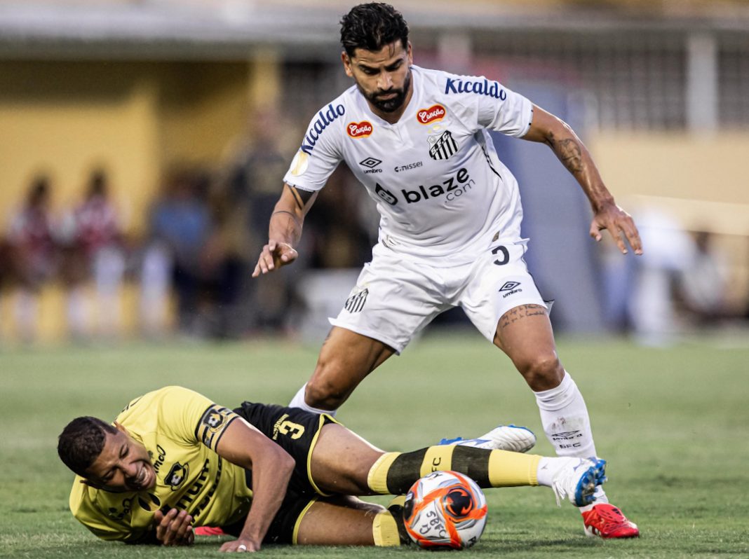 Jogador de futebol do Santos ganhando a bola