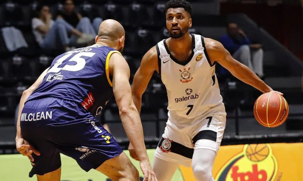 Jogador do Corinthians Basquete conduz a bola enquanto é marcado por um adversário do São José durante partida do NBB.